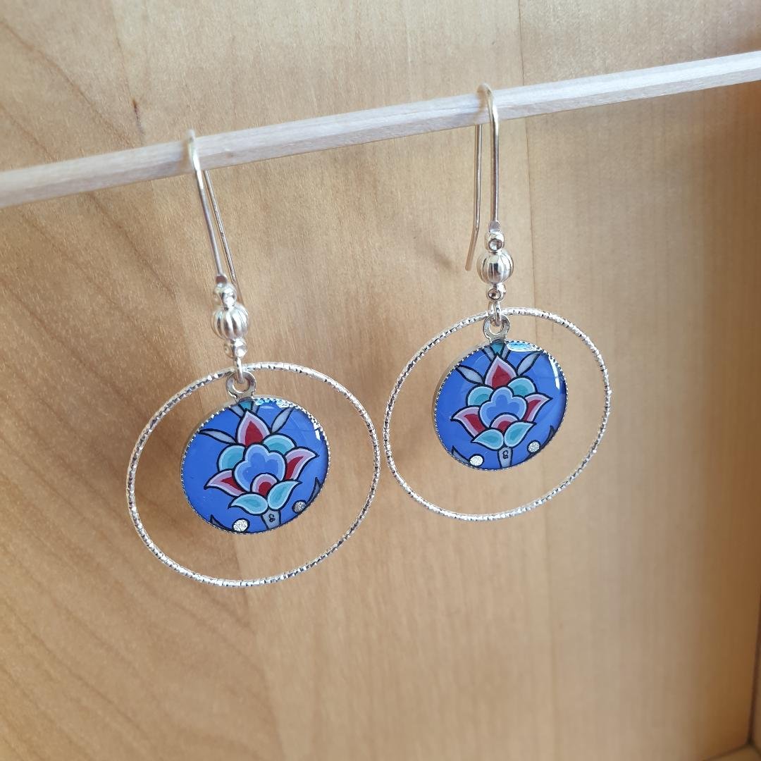 Boucles d'oreille pendantes enluminées fleur sur fond bleu